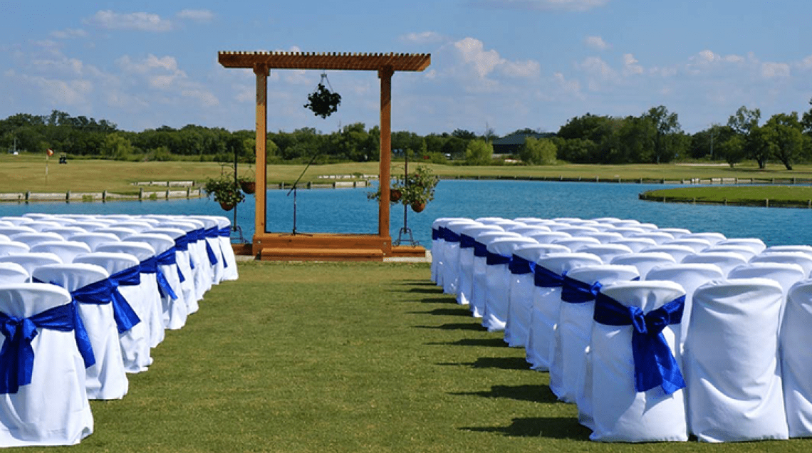wedding aisle with blue ribbons on chairs